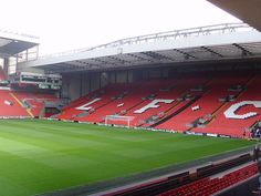 an empty soccer stadium with red seats