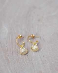 These elegant Shell Drop Earrings are meticulously crafted with 18k gold vermeil and features a gold shell complemented with a tiny pearl drop. These can be worn 3 different ways - the gold scallop shell facing out, the shell with pearl facing out, or just as simple gold hoops without the charm! Gold Shell With Pearl Drop, Elegant Shell-shaped Gold Hoop Earrings, Elegant Gold Shell Hoop Earrings, Gold Shell-shaped Hoop Earrings For Pierced Ears, Gold Shell-shaped Hoop Earrings, Single Shell-shaped Gold Earring, Gold Shell-shaped Pearl Earrings, Gold-plated Shell-shaped Earrings, Gold Shell Earrings With Pearl Charm