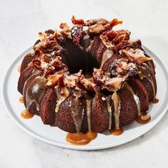 a chocolate bundt cake with caramel drizzled on the top and toppings