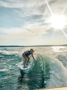 a woman riding a surfboard on top of a wave in the middle of the ocean