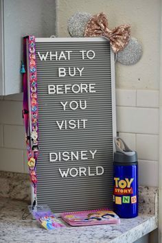 a sign that says what to buy before you visit disney world next to a toy story book