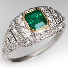 This gorgeous ring is centered with an emerald cut emerald, weighing 1.00 carat, in a yellow gold plated bezel. The top of the ring is bead set with fifty-eight (58) round single cut diamonds and accented with milgrain details. The ring measures 9.9mm at the top, rises 4.8mm above the finger, tapering to 1.7mm wide and 1.1mm thick at the base of the shank. It is currently a size 6.5. The emerald is unnoticeably chipped. Luxury Square Cut Emerald Jewelry, Elegant Green Emerald Ring With Bezel Setting, Formal Rectangular Emerald Ring With Center Stone, Heirloom Green Diamond Ring With Diamond Cut, Classic Green Baguette Cut Diamond Ring, Fine Jewelry Octagon Emerald Ring With Diamond Accents, Fine Jewelry Square Cut Emerald Ring For Anniversary, Rectangular Emerald Diamond Ring For Formal Occasions, Square Cut Emerald Jewelry For Formal Occasions