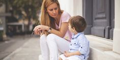 a woman sitting next to a little boy