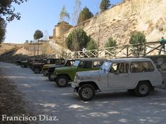 several jeeps parked on the side of a road