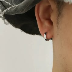 a man wearing a black hat and silver earring