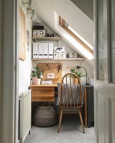 a chair sitting in front of a desk under a slanted roof