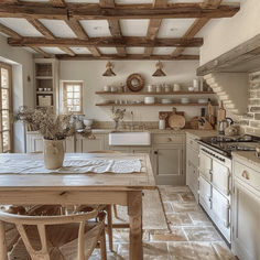 an old fashioned kitchen with white appliances and wood beams on the ceiling, along with wooden dining table