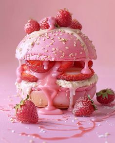 a pink cake with strawberries on top and icing drizzled over it