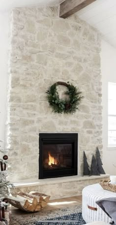 a living room decorated for christmas with a fireplace and wreath on the wall above it