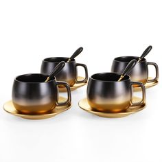 three black and gold coffee cups with spoons