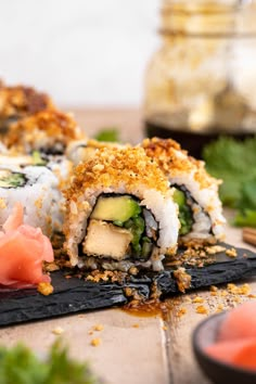 sushi rolls with cucumber, avocado and other toppings on a cutting board