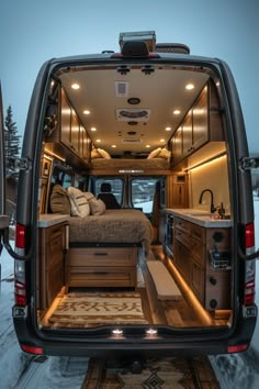 the back end of an rv with its bed and kitchen area in the snow covered ground