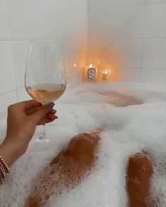 a person holding a wine glass in a bubble bath