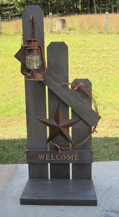 a welcome sign with a star on it and a lantern hanging from the top of it