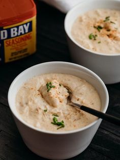 two white bowls filled with dip and garnished with parsley on the side