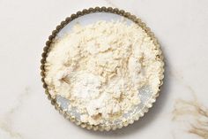 a pie pan filled with flour on top of a marble counter