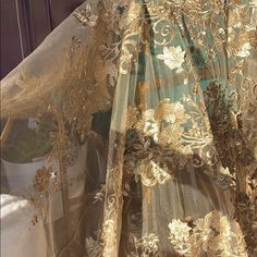 an elaborate gold and green dress with flowers on it