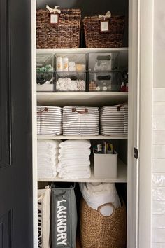 an organized closet with baskets, towels and other items in it's shelves for storage