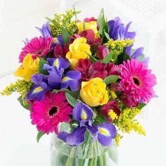 a vase filled with lots of colorful flowers