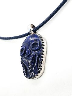 Lapis Lazuli hand carved skull pendant sterling silver custom corded chain. Good vintage condition with little signs of normal wear. Custom braided corded chain with sterling silver capped clasp. Clasp opens with push button on the side. Pendant is set in sterling silver with large saw tooth bezel. Pendant stamped on the back 925. Acid tests positive for sterling silver. Necklace measures 18 inches long. Pendant measures 2 inches long and 1 inch wide. Adjustable Carved Sterling Silver Jewelry, Handmade Adjustable Skull Jewelry, Carved Pendant Jewelry, Adjustable Carved Pendant Jewelry, Artisan Carved Adjustable Jewelry, Artisan Silver Jewelry With Adjustable Cord, Carved Skull, Silver Caps, Saw Tooth