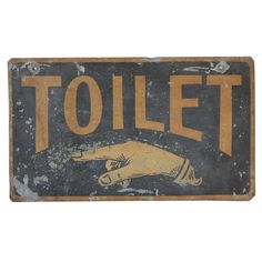 an old metal sign that says toilet with a hand pointing towards the viewer