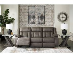 the reclining sofa is in front of a brick wall