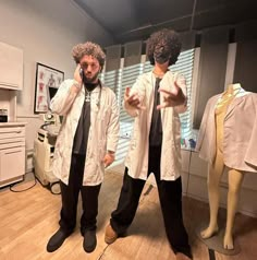 two mannequins dressed in white shirts and black pants are talking on their cell phones