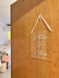 a wooden sign hanging from the side of a wall next to a child's bed