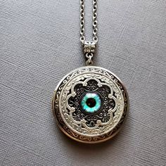 Large Locket Dragon Eye Necklace ☻Locket ~ Large, Decoratively Styled ~ Measures 1.77 inches round See Photos for size comparison against American quarter Chain: ~ Silver Plated YOU CHOOSE YOUR CHAIN LENGTH during checkout ☻More Lockets Here: https://www.etsy.com/shop/FashionCrashJewelry/search?search_query=lockets&order=date_desc&view_type=gallery&ref=shop_search ☻Link to The ENTIRE SHOP: https://www.etsy.com/shop/FashionCrashJewelry?ref=shopsection_shophome_leftnav&ga_search_qu Turquoise Round Pendant Jewelry Gift, Turquoise Round Pendant Jewelry As Gift, Bohemian Nickel-free Pendant Locket Necklace, Unique Antique Silver Medallion Jewelry, Turquoise Round Spiritual Jewelry, Adjustable Bohemian Jewelry Keepsake, Bohemian Adjustable Jewelry For Keepsake, Unique Round Turquoise Jewelry, Antique Silver Spiritual Locket Jewelry