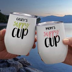 two women holding up white wine glasses with the words mommy's sippy cup on them