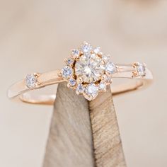 a diamond ring sitting on top of a piece of wood