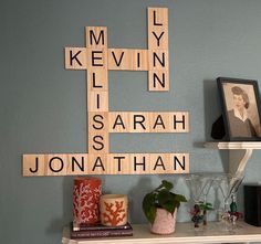 scrabble tiles are arranged on the wall above a shelf with vases and candles