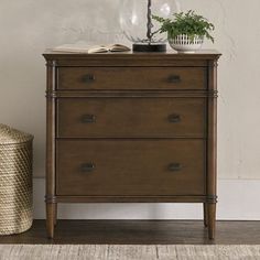 a wooden dresser sitting next to a plant on top of a table