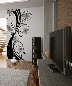 a modern living room with flowers painted on the wall and stairs leading up to the second floor