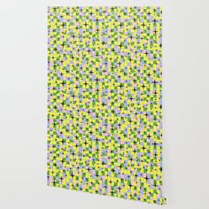 a yellow and green wallpaper with small squares in the center, on top of a white wall