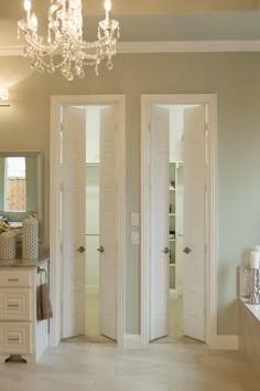 a bathroom with two doors and a chandelier