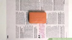 a piece of orange soap sitting on top of a newspaper