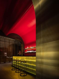 a row of chairs sitting next to each other in front of a red and yellow wall