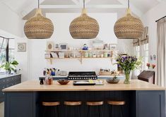 a kitchen with three hanging lights above the island