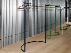 a row of circular metal racks in front of a wall