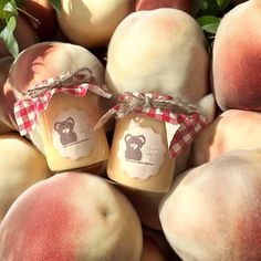 two jars of honey sitting on top of peaches