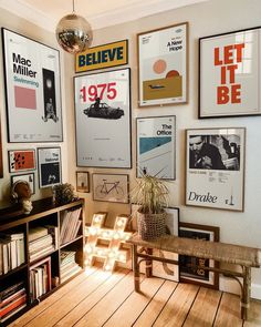 a room filled with lots of posters on the wall next to a wooden table and bookshelf