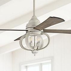 a ceiling fan with two light bulbs hanging from it's blades in a white room