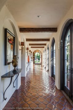 the hallway is lined with arched windows and doors