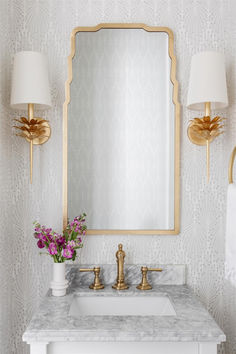 a bathroom vanity with a mirror, sink and two lights on the wall above it