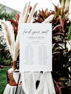 a wedding seating plan is displayed in front of some plants