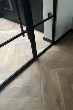 an open glass door on top of a wooden floor