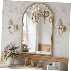 a bathroom with a sink, mirror and flowers on the counter in front of it