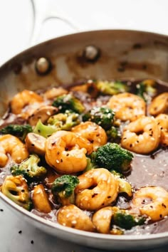 broccoli and shrimp are being cooked in a skillet