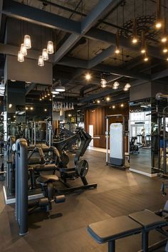 an empty gym with many machines and benches